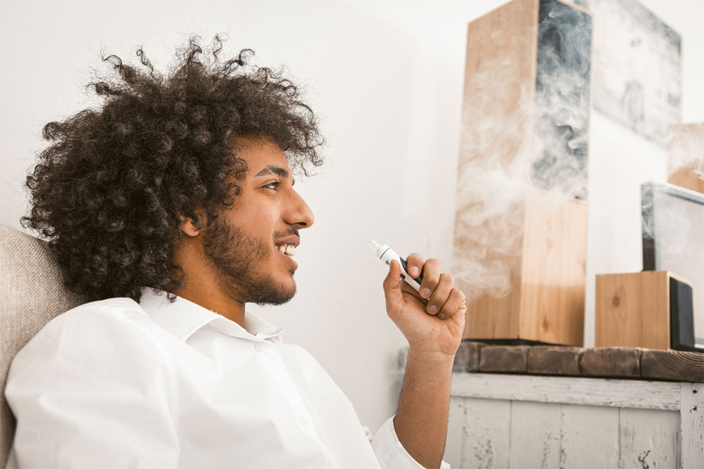 Jeune homme afro vapoteur