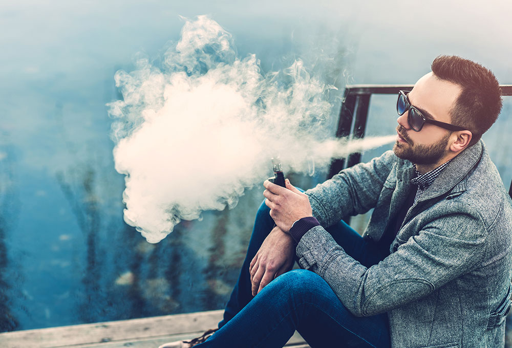 Jeune homme afro vapoteur